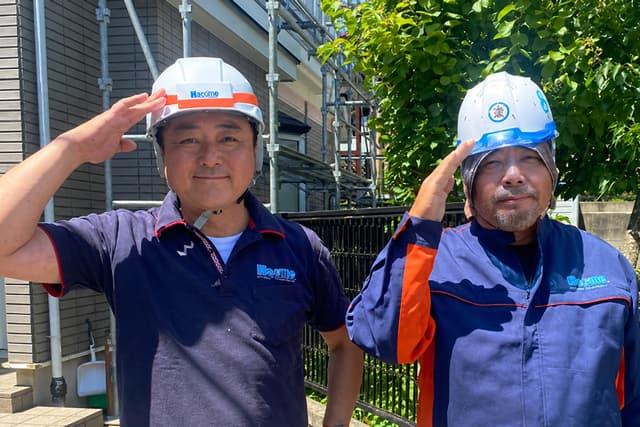 現場でヘルメットをかぶり挨拶する八戸ペイントの職人
