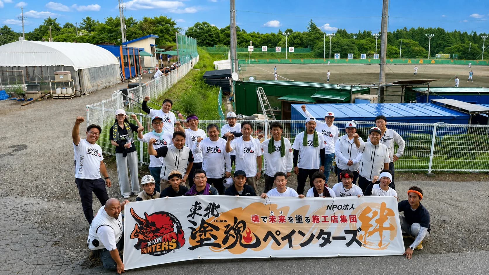 横断幕の前に並ぶ塗魂ペインターズの集合写真