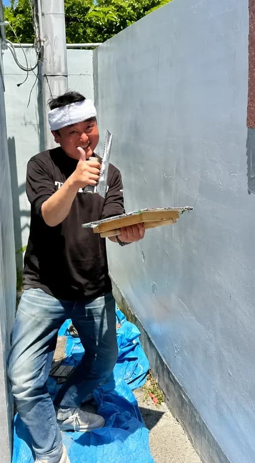 外壁に刷毛を入れる職人