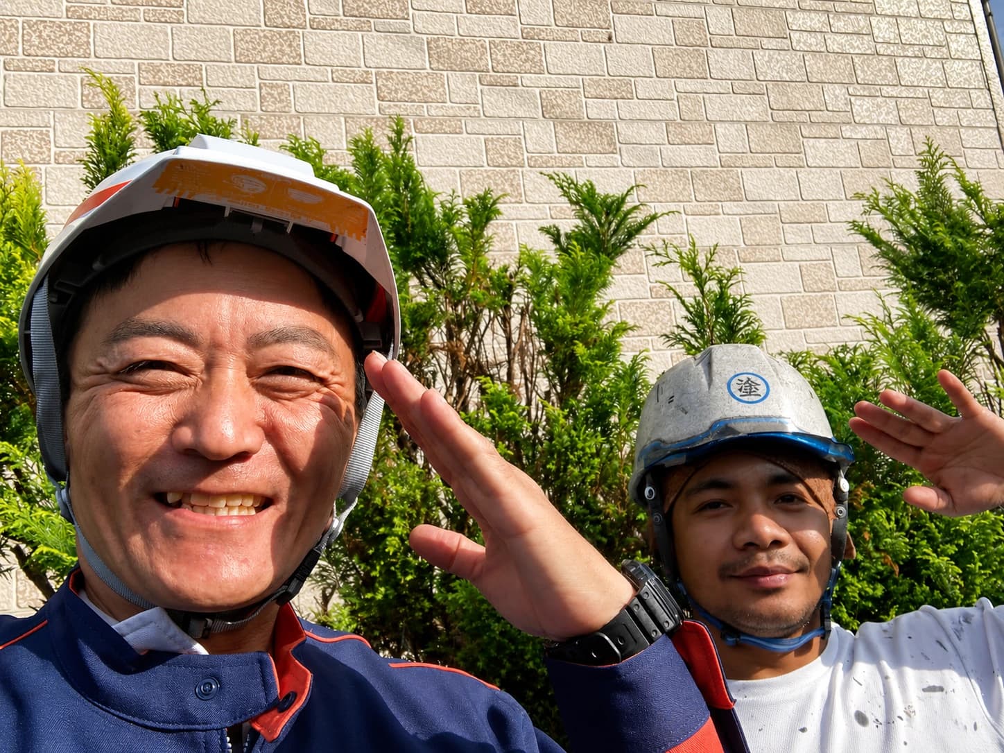 現場で並んで立つ八戸ペイントの職人2人